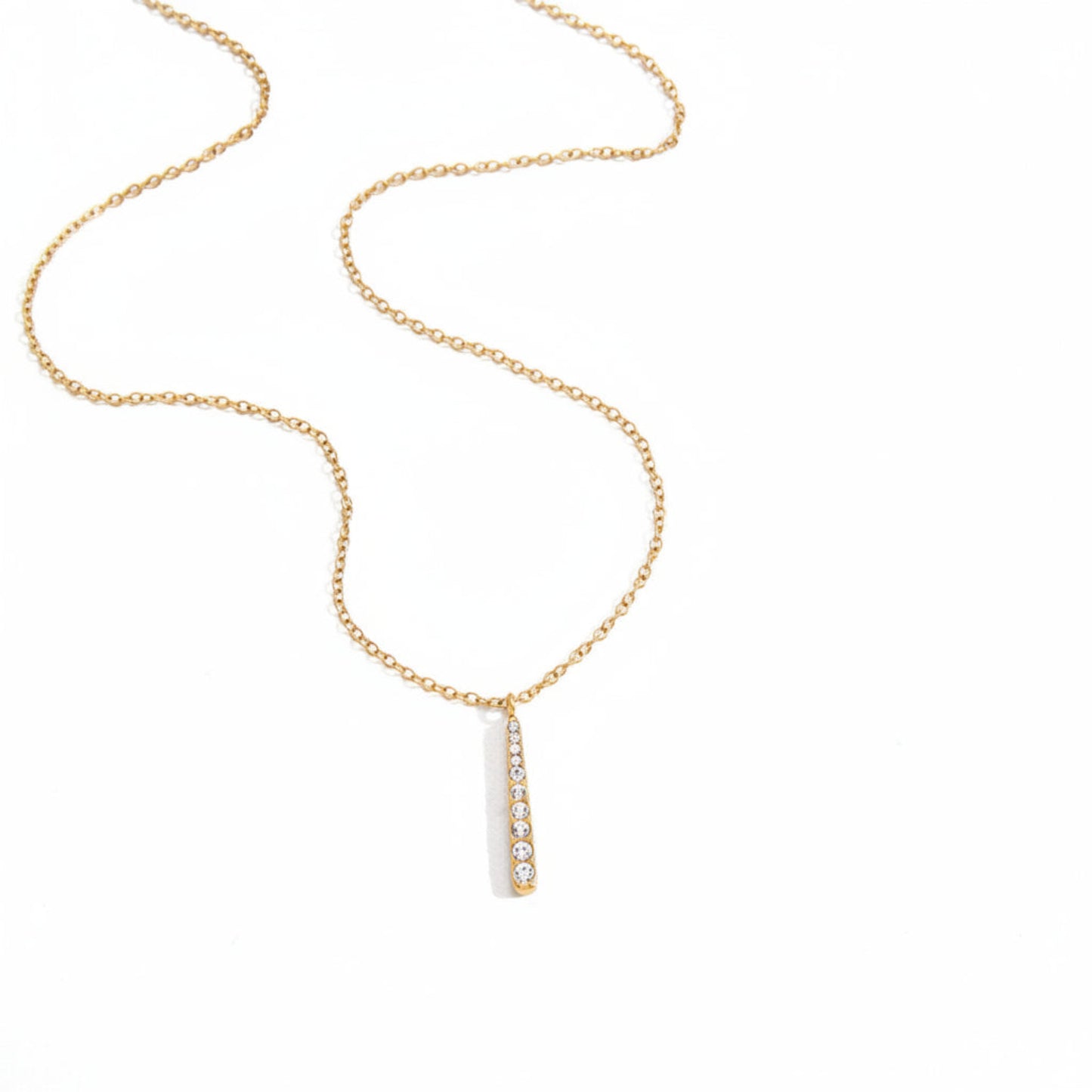 Gold necklace and earrings with clear stones on a white background