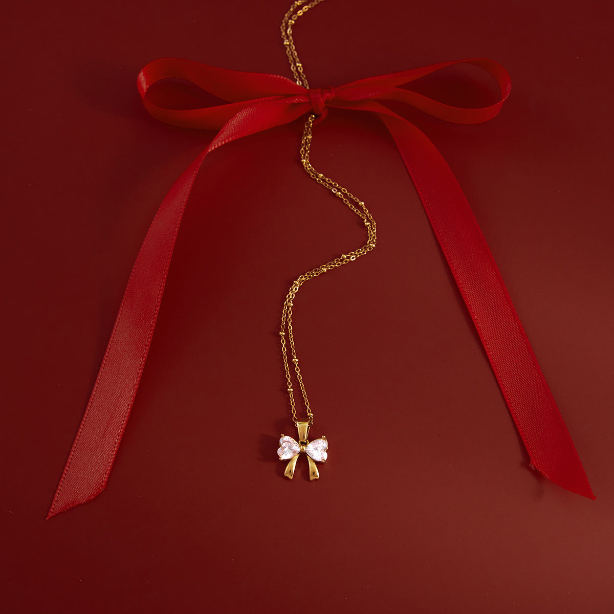 Gold - Plated Bow - Shaped Pendant Necklace with Heart - Cut Crystals