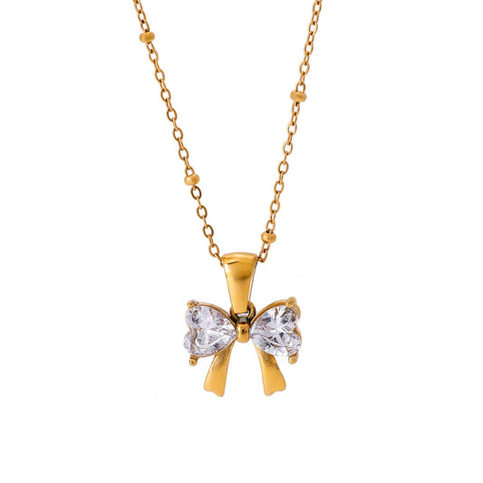 Gold bow-shaped necklace with clear stones on a white background