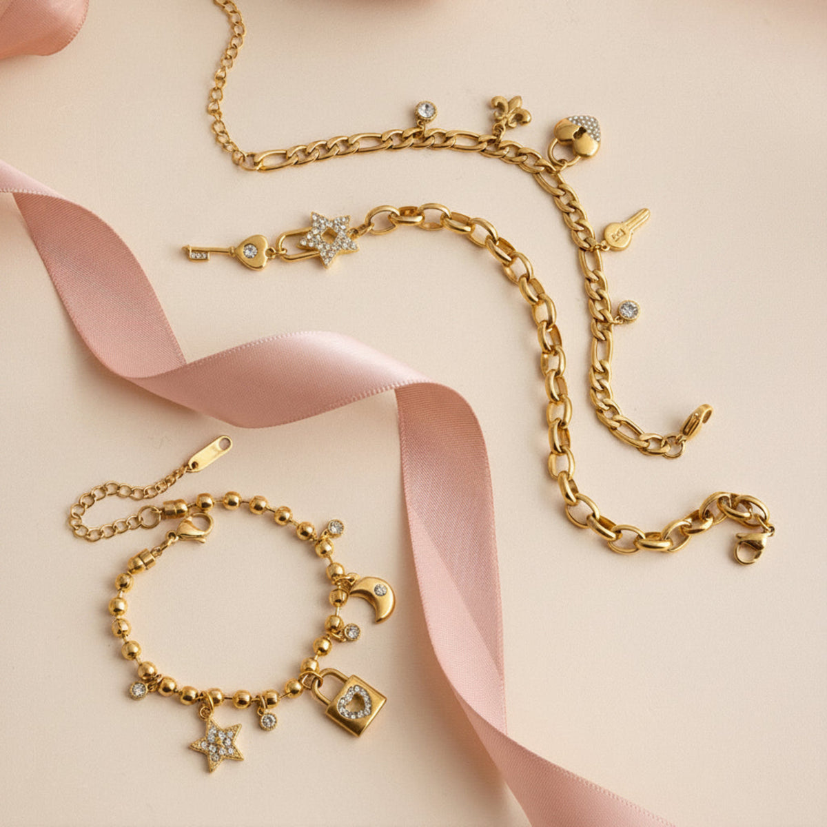 Gold bracelet with charms on a pink ribbon and beige background