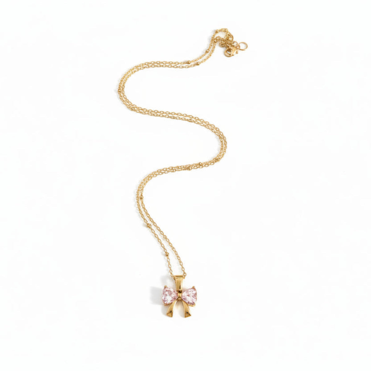 A delicate gold chain necklace featuring a bow-shaped pendant with light pink gemstones, displayed on a clean white background.