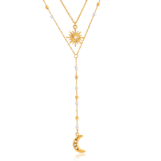 Gold necklace with sun and moon pendants on a white background
